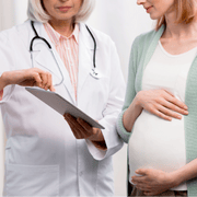 Pediatra atendiendo a un bebé en el Hospital MediFam, Sololá, con una madre vestida en traje tradicional, mostrando atención culturalmente inclusiva.